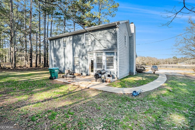 rear view of property featuring a yard and a patio