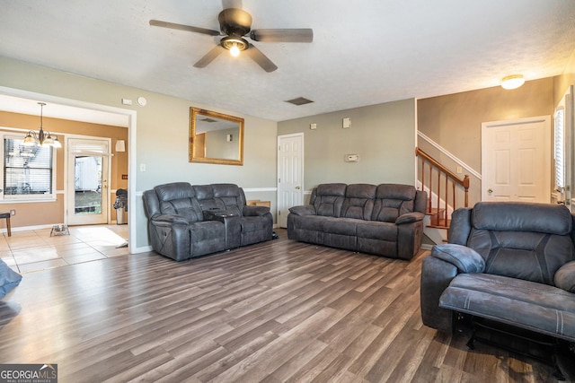 living room with hardwood / wood-style floors and ceiling fan with notable chandelier