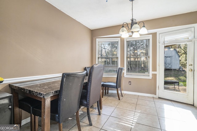 dining space with vaulted ceiling, a chandelier, light tile patterned floors, and plenty of natural light