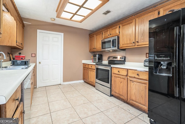 kitchen with sink, light tile patterned floors, and stainless steel appliances