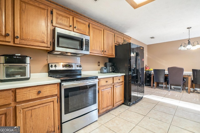 kitchen with pendant lighting, a chandelier, light tile patterned floors, and appliances with stainless steel finishes