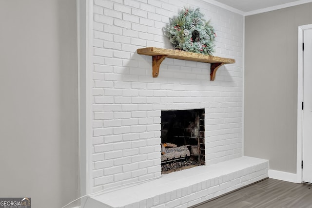 details with a brick fireplace, hardwood / wood-style flooring, and crown molding