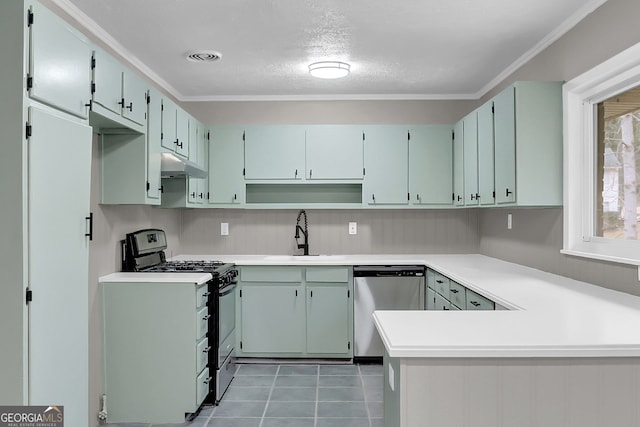 kitchen featuring dark tile patterned flooring, kitchen peninsula, sink, crown molding, and appliances with stainless steel finishes