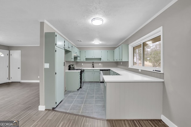 kitchen featuring a textured ceiling, stainless steel appliances, crown molding, and sink