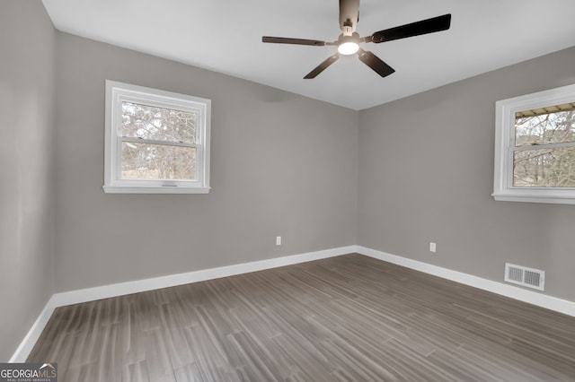 spare room with ceiling fan and dark hardwood / wood-style flooring