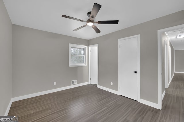 unfurnished bedroom with ceiling fan and dark hardwood / wood-style floors