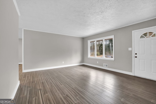 foyer with dark hardwood / wood-style floors, crown molding, and a textured ceiling