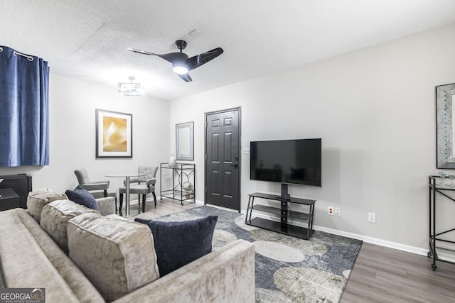 living room featuring a textured ceiling, ceiling fan, and hardwood / wood-style floors