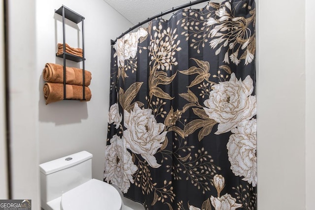 bathroom featuring toilet and a textured ceiling