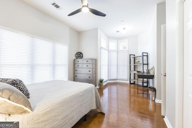 bedroom with ceiling fan, multiple windows, wood-type flooring, and vaulted ceiling