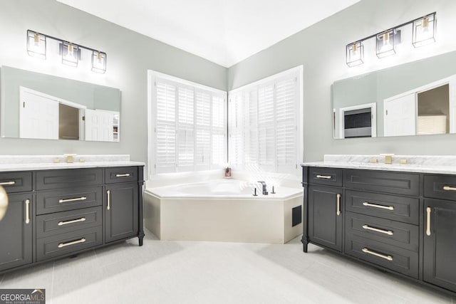 bathroom featuring tile patterned floors, vanity, and a bathing tub