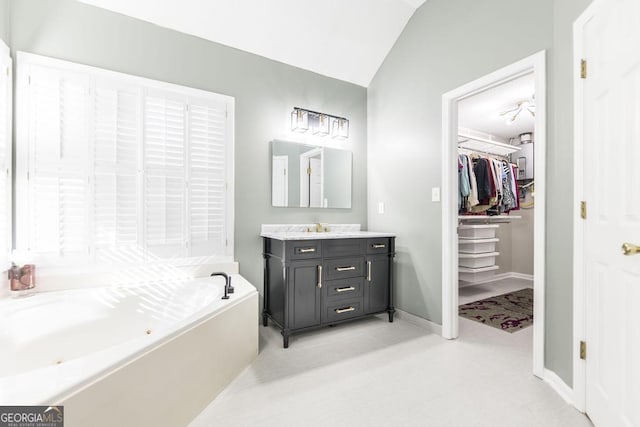 bathroom with vanity, vaulted ceiling, and a bathing tub