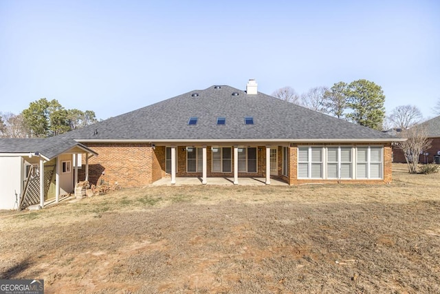 back of house featuring a lawn and a patio