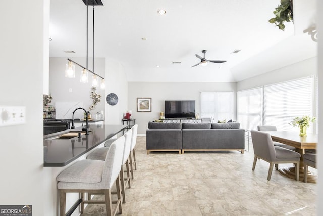 living room featuring ceiling fan and sink