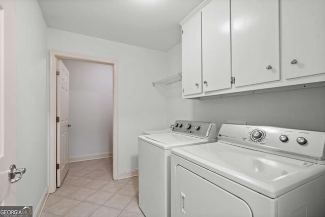 clothes washing area featuring cabinets, separate washer and dryer, and light tile patterned floors