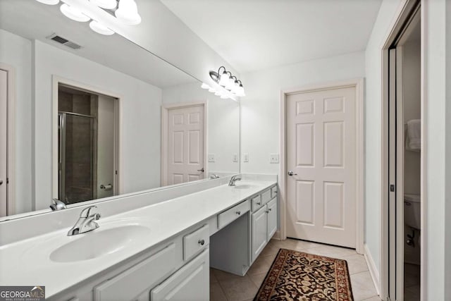 bathroom featuring toilet, tile patterned flooring, an enclosed shower, and vanity