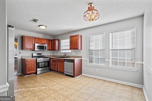 kitchen with hanging light fixtures, sink, and stainless steel appliances