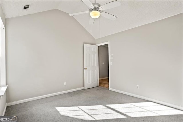 carpeted empty room featuring vaulted ceiling and ceiling fan