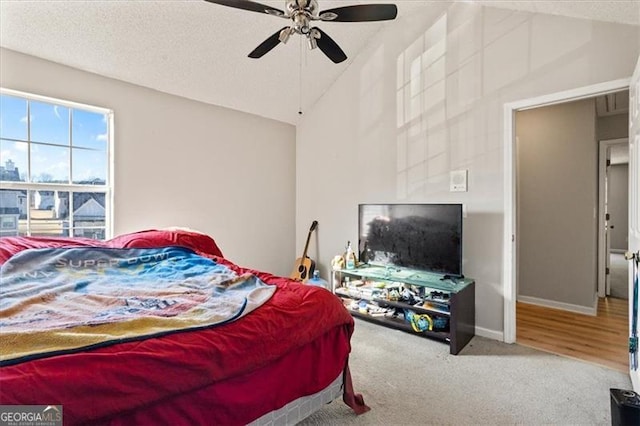 bedroom featuring ceiling fan, a textured ceiling, lofted ceiling, and carpet flooring