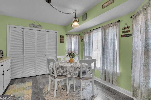 dining area with dark hardwood / wood-style floors and a textured ceiling