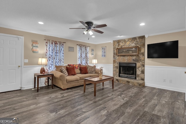 living room featuring crown molding, a stone fireplace, and dark hardwood / wood-style floors