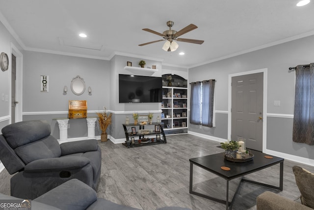 living room with hardwood / wood-style flooring, ceiling fan, and ornamental molding