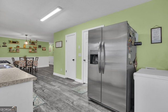 kitchen with sink, hardwood / wood-style flooring, fridge, stainless steel fridge, and pendant lighting