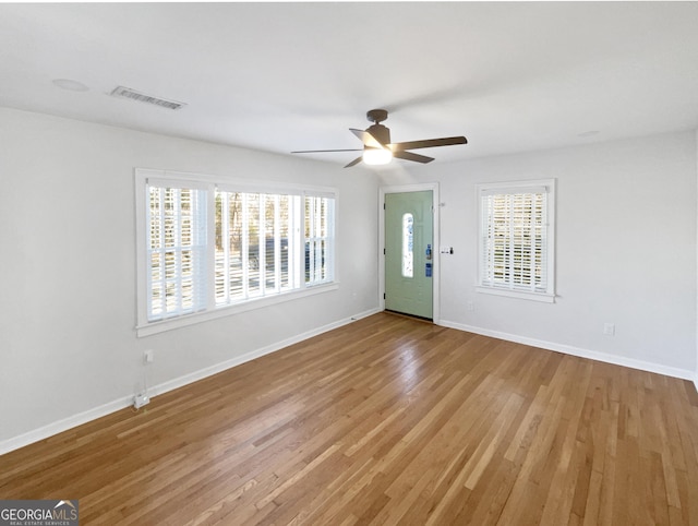 empty room with ceiling fan and light hardwood / wood-style floors