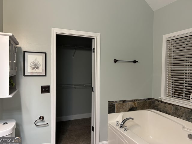 bathroom featuring a washtub and toilet