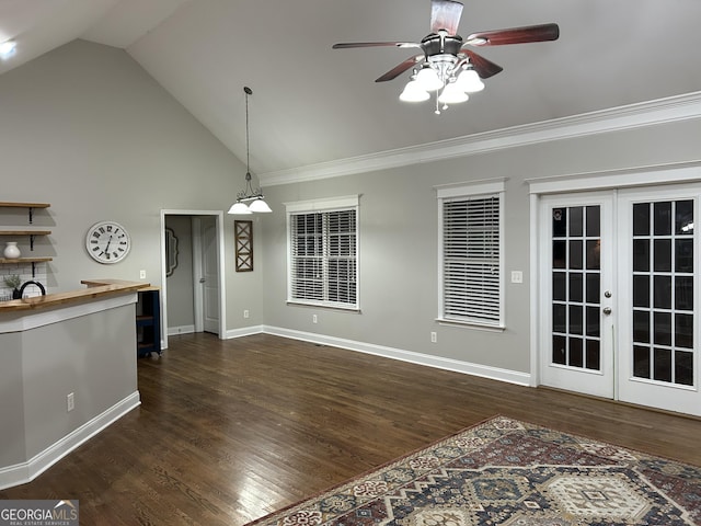 unfurnished living room featuring ceiling fan, dark hardwood / wood-style floors, crown molding, high vaulted ceiling, and french doors