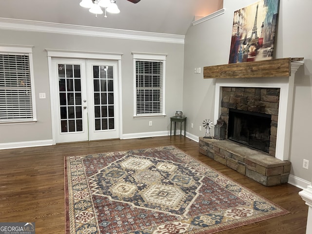 living room with ceiling fan, ornamental molding, french doors, and a stone fireplace