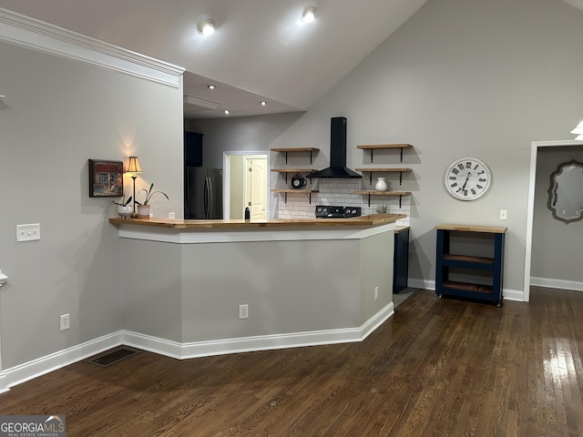 kitchen with black appliances, lofted ceiling, wall chimney exhaust hood, backsplash, and kitchen peninsula