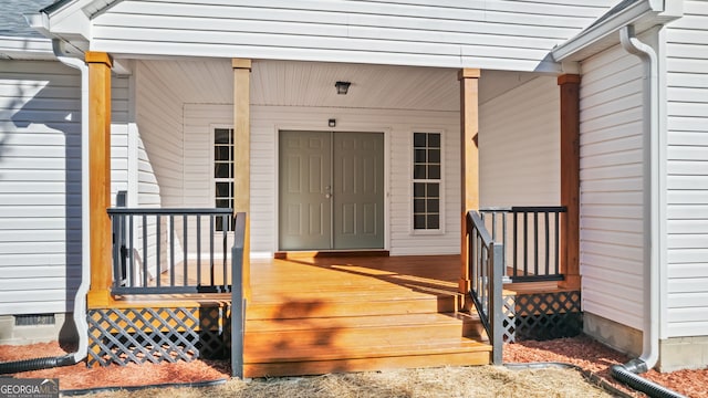 view of exterior entry featuring covered porch