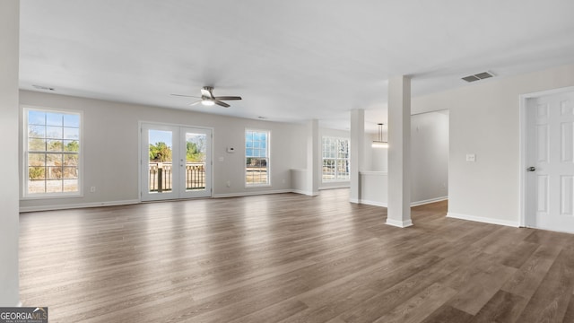 unfurnished living room with ceiling fan, french doors, and dark wood-type flooring