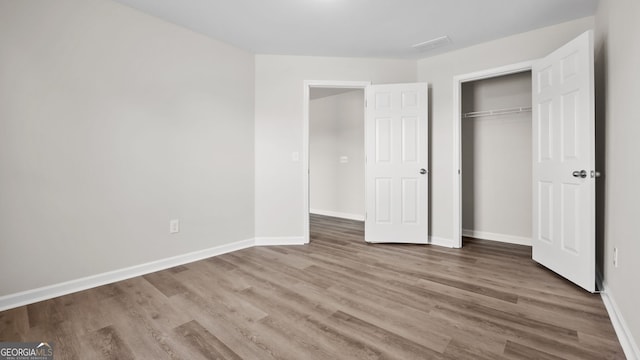 unfurnished bedroom with a closet and hardwood / wood-style flooring