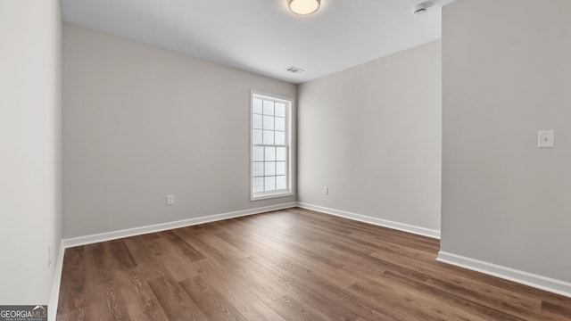 spare room with dark hardwood / wood-style flooring