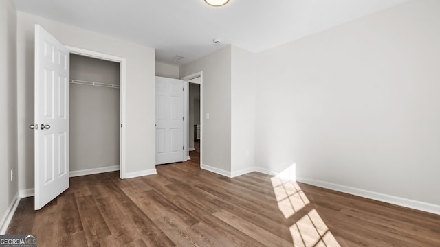 unfurnished bedroom featuring a closet and hardwood / wood-style flooring