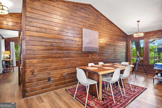 dining space with vaulted ceiling and hardwood / wood-style floors