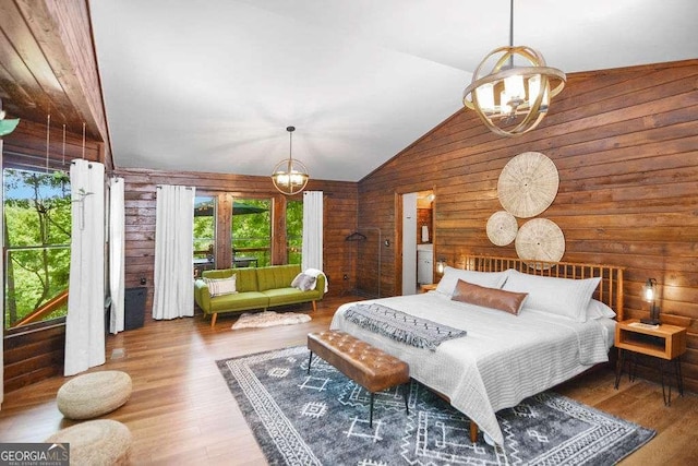 bedroom featuring hardwood / wood-style flooring, lofted ceiling, and an inviting chandelier