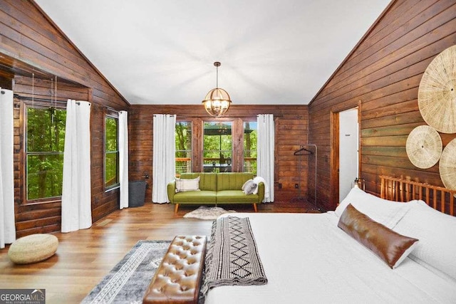 bedroom with light hardwood / wood-style flooring, a notable chandelier, and vaulted ceiling