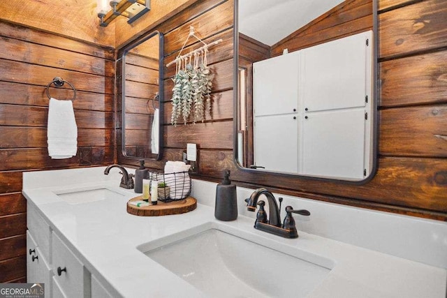 bathroom with vanity, vaulted ceiling, and wooden walls