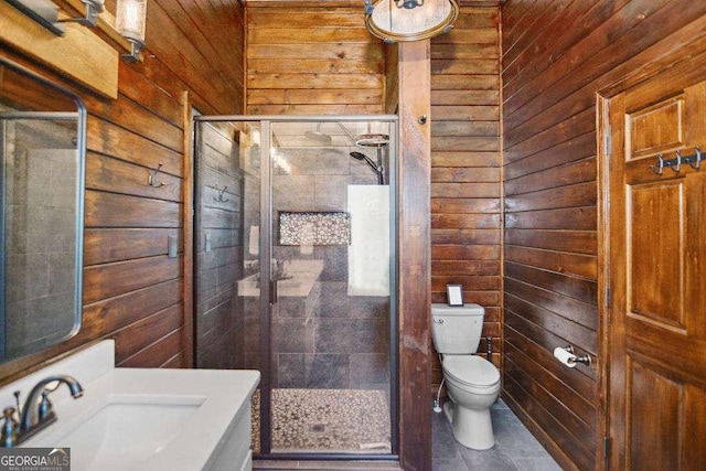 bathroom featuring tile patterned floors, sink, toilet, wood walls, and a shower with shower door