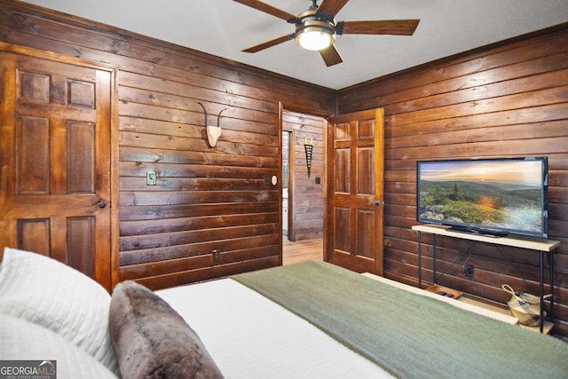 bedroom featuring ceiling fan and wooden walls