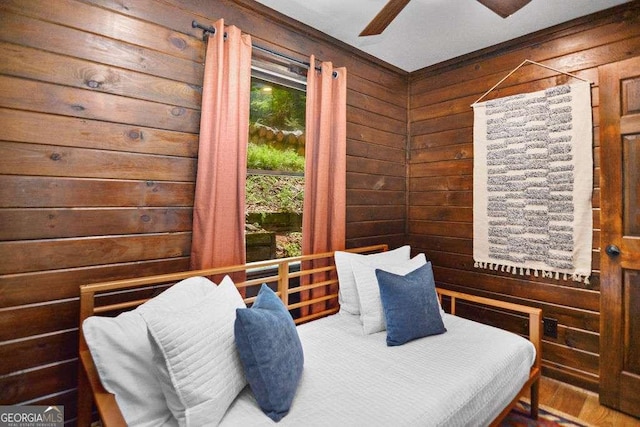 bedroom with ceiling fan and wooden walls