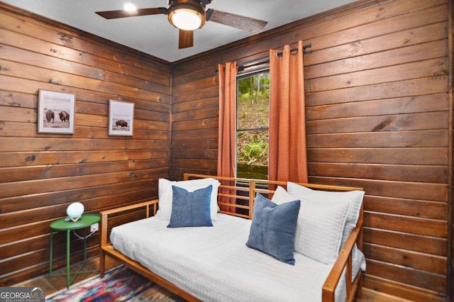 bedroom featuring ceiling fan and wooden walls