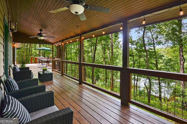 deck featuring ceiling fan and an outdoor living space