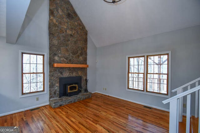 unfurnished living room featuring high vaulted ceiling and hardwood / wood-style floors