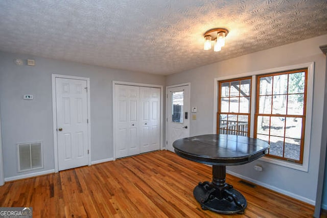 interior space with dark wood-type flooring and a textured ceiling