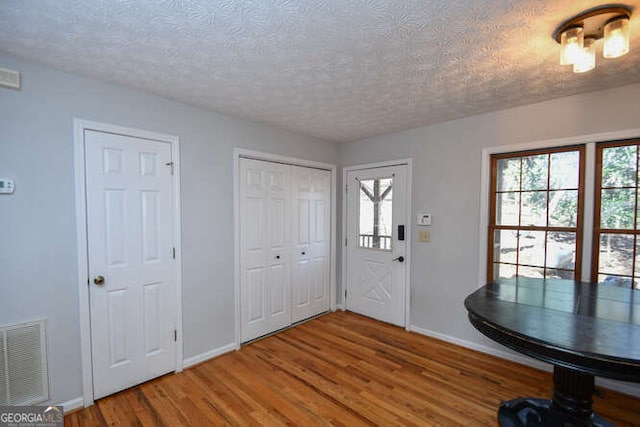 entryway with a textured ceiling and hardwood / wood-style flooring