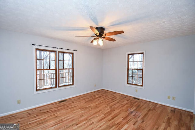 unfurnished room with a textured ceiling, ceiling fan, and light hardwood / wood-style floors